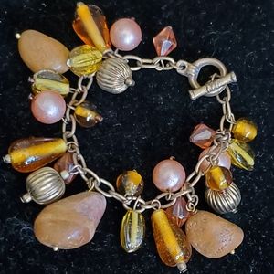 Brass tone bracelet with bead and stone charms, toggle closure brown